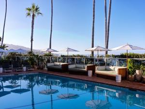a swimming pool with couches and palm trees at Casa Loma Beach Hotel in Laguna Beach +17 photos