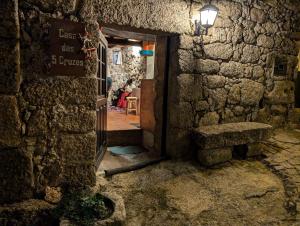 an entrance to a stone building with a sign on the door at Casa das 5 Cruzes dentro da muralha in Sortelha