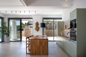 cocina con mesa de madera y encimera en Agapanthus Ultimate Luxury Villa, en Likotinaréa