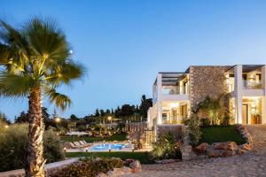un edificio con una palmera y una piscina en Agapanthus Ultimate Luxury Villa, en Likotinaréa
