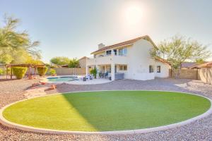 a house with a green lawn in front of a pool at Centrally Located Cave Creek Retreat with Backyard in Cave Creek