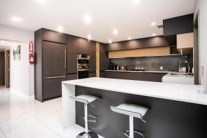 eine Küche mit schwarzen Schränken und weißen Arbeitsplatten in der Unterkunft Premium Luxury 5BR & 3BA Villa near Hollywood Beach in Hollywood