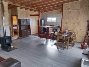 a kitchen and dining room with a table and a stove at Cabaña Lañusta in Puerto Montt