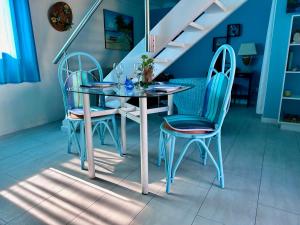 a dining room table with two chairs and a staircase at Sun Caraibes in Orient Bay