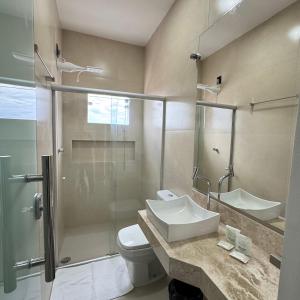 a bathroom with a toilet and a sink and a shower at Pousada Brumado in Brumado +53 photos