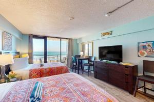 Una habitación de hotel con dos camas y un televisor de pantalla plana. en Hawaiian Inn 322, en Daytona Beach Shores