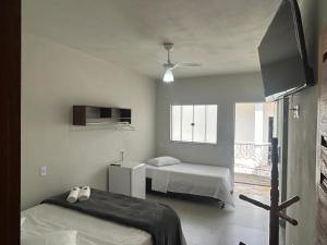 a hospital room with two beds and a window at Pousada do Cid in São Thomé das Letras