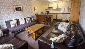 a living room with two couches and a kitchen at The Park Guest House, Stornoway in Stornoway