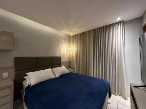 a bedroom with a blue bed and a window at iFlat Winner Sport Life Jardim Goiás in Goiânia +12 photos