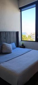 um quarto com uma cama grande e uma janela grande em Luxo Studio Facing the Sea em Puerto Vallarta
