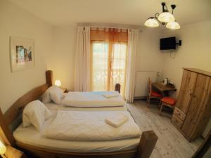 a bedroom with two beds and a desk and a window at Seehotel am Hallstättersee in Obertraun