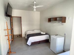 a hospital room with two beds and a refrigerator at Pousada do Cid in São Thomé das Letras