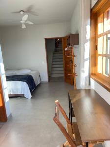 a room with a bed and a table and a chair at Pousada do Cid in São Thomé das Letras +42 photos