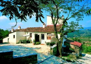 a white house with a tree in front of it at Agriturismo Montereggi in Fiesole