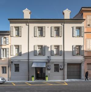 a large white building with a garage at Smart Hotel in Carpi