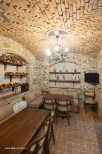 a restaurant with a table and chairs and a stone wall at Moonlight Serenade in Korçë