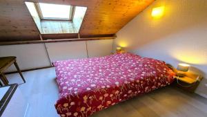 a bedroom with a bed with a red bedspread and a window at Résidence Les Anémones - Agréable T2 en duplex avec balcon 4 personnes MAE-6861 in Vallouise