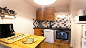 a kitchen with wooden cabinets and a counter top at Résidence Les Cytises - Agréable T2 avec jardin et terrasse 4/6 personnes MAE-6871 in Vallouise +1 photo