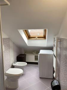 a bathroom with a toilet and a skylight at Splendid Mansarda Issiglio - BORGO SAN PAOLO - PARCO RUFFINI in Turin