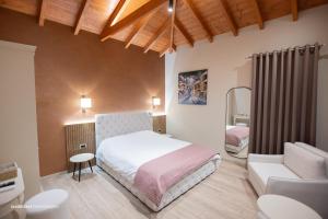 a bedroom with a bed and a chair and a couch at Moonlight Serenade in Korçë