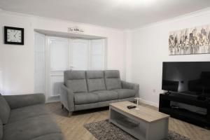 a living room with a couch and a tv at Greatmindz abode in Kingshurst