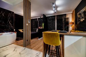 a kitchen with a bar with a yellow stool at Apartament American Express Rzeszów in Rzeszów