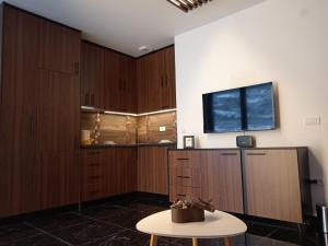 a room with wooden cabinets and a table and a tv at Dolce Vita in Užice