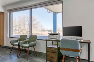 a room with three chairs and a desk with a television at Hotel Blue 66, BW Signature Collection in Santa Rosa