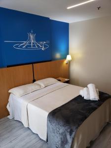 una camera da letto con un letto grande con una parete blu di Flat 811 - Hotel Comfort Taguatinga a Brasilia