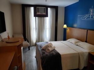 una stanza d'albergo con un letto con un asciugamano sopra di Flat 811 - Hotel Comfort Taguatinga a Brasilia Altre 14 foto