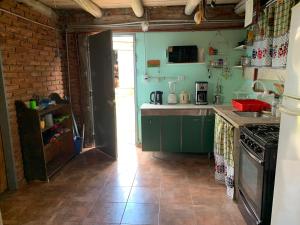 a kitchen with green cabinets and a brick wall at La Roca in Estancia Vieja