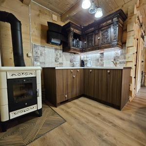 a kitchen with a stove and a counter top at Domki góralskie z sauną i jacuzzi in Kościelisko