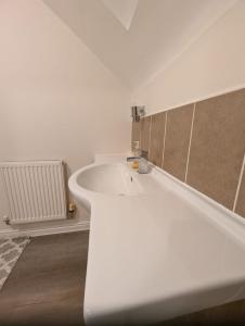 a white bathroom with a sink and a bath tub at Greatmindz abode in Kingshurst +20 photos