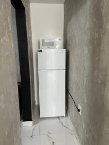a white refrigerator with a microwave on top of it at Molinos House 1 in Santa Isabel