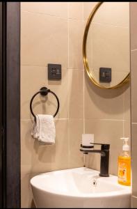 a bathroom with a sink and a mirror at Lifestyle Studio Apartment Escada 101 with Balcony in Nairobi