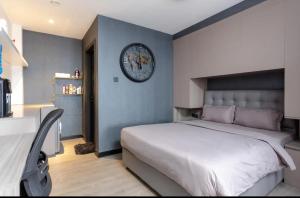 a bedroom with a large bed and a clock on the wall at Lifestyle Studio Apartment Escada 101 with Balcony in Nairobi