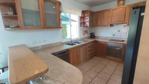 una cucina con mobili in legno e un piano di lavoro di Wonderful Beach Villa, Perfect Location a Khao Lak