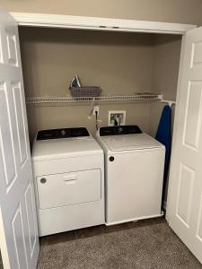 two washing machines in a laundry room with a door at Spacious, 4BR Boho - Family & Pet Friendly in Clarksville +25 photos