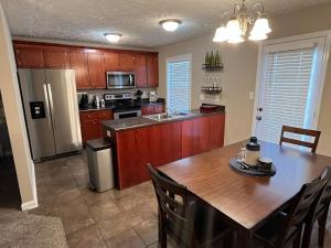 a kitchen with a wooden table and a refrigerator at Spacious, 4BR Boho - Family & Pet Friendly in Clarksville