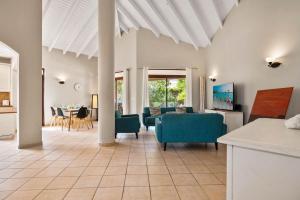 a living room with blue chairs and a table at Caya Bista Lama 26 in Palm-Eagle Beach