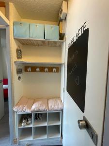 - un casier avec étagères et tableau noir sur le mur dans l'établissement Lili Home Bellecôte - La Plagne, à La Plagne Tarentaise