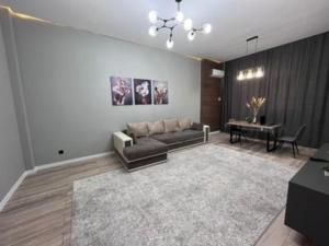 ein Wohnzimmer mit Sofa und Tisch in der Unterkunft ЖК New City двухкомнатные уютная апартаменты in Atyrau