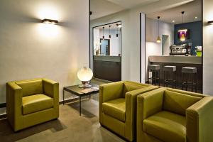 uma sala de estar com duas cadeiras e um bar em Smart Hotel em Carpi