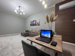 ein Wohnzimmer mit einem Laptop auf einem Holztisch in der Unterkunft ЖК New City двухкомнатные уютная апартаменты in Atyrau