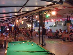 a pool table in a restaurant with a crowd of people at Club Sunset Apartments in Marmaris