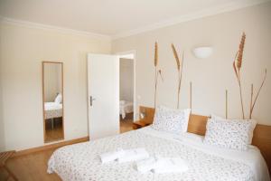 a bedroom with a bed with two white towels on it at Sintra Sol - Apartamentos Turisticos in Sintra