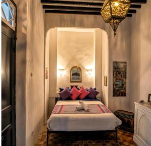 丹吉尔Authentic Riad with Bay View - Heart of Kasbah by CozyHome的卧室里有一张大床，配有红色枕头