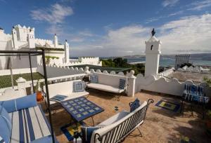 丹吉尔Authentic Riad with Bay View - Heart of Kasbah by CozyHome的一个带椅子的阳台和白色的建筑