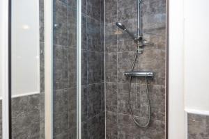 a bathroom with a shower with a glass door at The Oxford Cozy Stays in Stoke on Trent