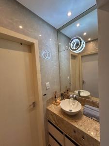 a bathroom with a sink and a mirror at Stella103, 50m da praia! in Salvador +33 photos